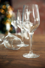Empty wine glasses on wooden table against blurred background
