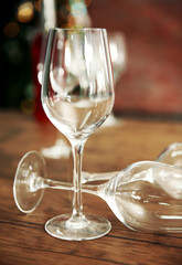 Empty wine glasses with bottle on wooden table against blurred background