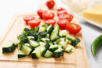 Female hands cutting vegetables for salad, at kitchen