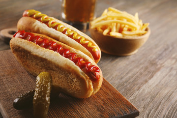 Hot dogs with fried potatoes on cutting board