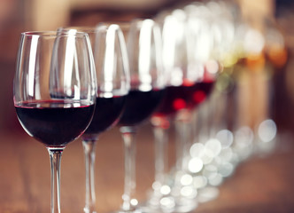Many glasses of different wine in a row on bar counter