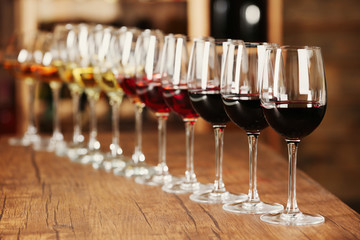 Many glasses of different wine in a row on bar counter