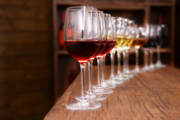 Many glasses of different wine in a row on bar counter