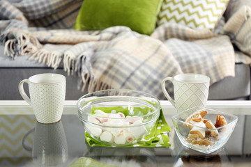 Low table with sweets and two cups in living room