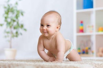 Adorable baby crawling on floor in the nursery