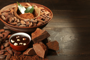 Aromatic cocoa harvest with tasty chocolate on wooden background, close up