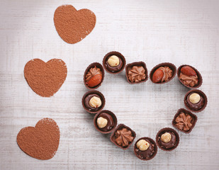 Sweet heart shaped candies on white wooden background