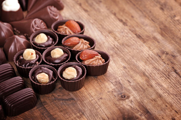 Delicious chocolate candies on wooden background