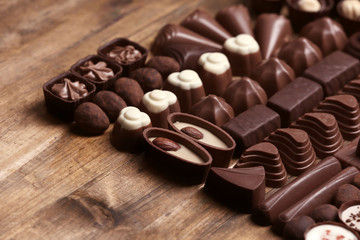 Delicious chocolate candies on wooden background