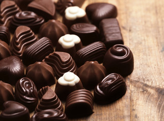 Delicious chocolate candies on wooden background