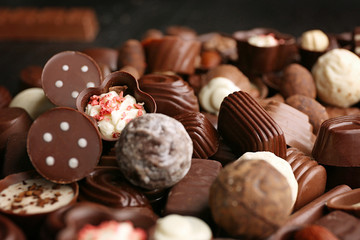 Assortment of delicious chocolate candies background, close up