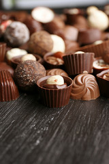 Delicious chocolate candies on wooden background
