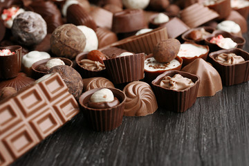 Delicious chocolate candies on wooden background