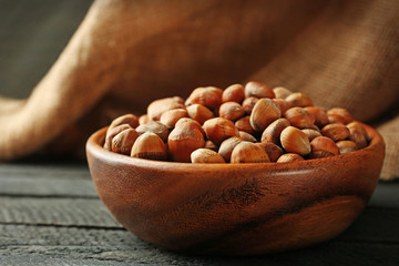 Hazelnuts in the bowl on the wooden table