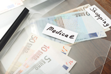 Distribution of money, financial planning, euro in envelopes, on wooden table background