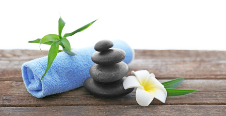 Spa stones with towel, bamboo and tropical flower on white  background