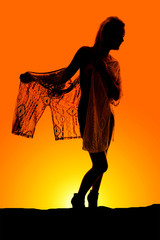 Silhouette of a woman wrapped in sheer cloth hold out look to si