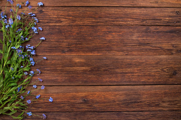 Forget-me-not flowers on wooden background, copy space