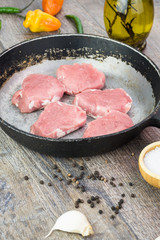 Uncooked pork tenderloin on the old pan.