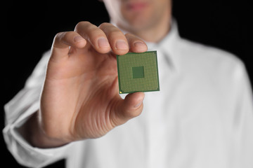 Man holding microprocessor in his hand on black background