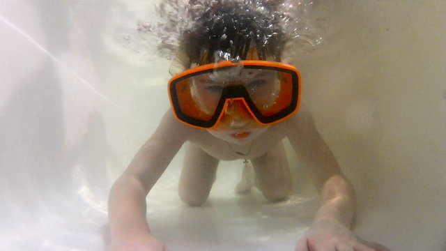 Happy cute little boy underwater