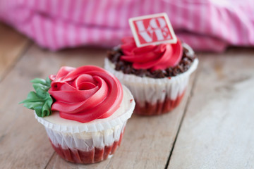 red rose cupcakes on wooden table