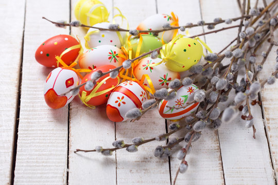 Decorative Eeaster eggs and willow branches on wooden background