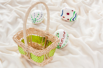 Painted Easter eggs on cloth - Natural white eggs with various patterns painted by hand for Easter ready for the hunt. Shallow Depth of field used for festive background with natural light.