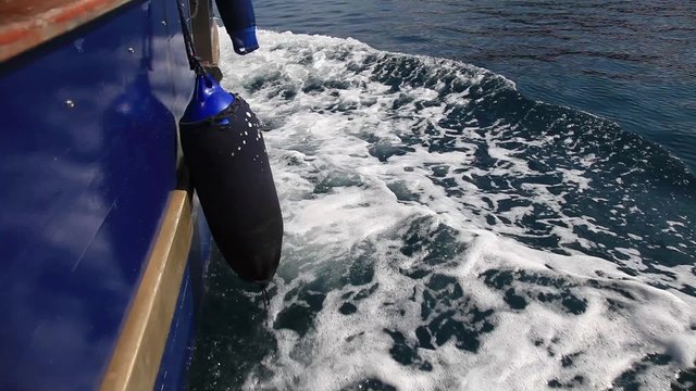 Details of wooden boat travel in blue mediterranean sea in summer vacation.