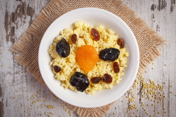 Cooked millet groats on white plate, healthy food and nutrition