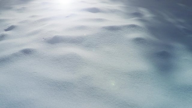 Sunny winter snowy countryside field floor closeup background. Right to left dolly slider move. 