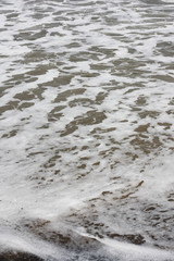 Obraz premium Frothy waves on beach - Frothy and foamy sea waves on a tropical beach.