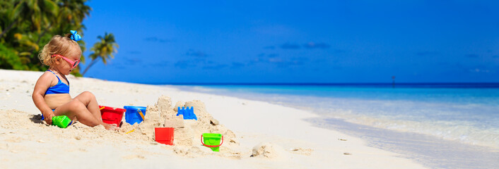 cute little girl play with sand on the beach