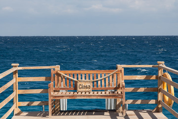 Bench on a pier with the plate "close"