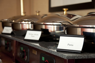 Food Caterer pans with food name cards on front at a wedding