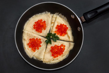 Pancakes with caviar in a pan