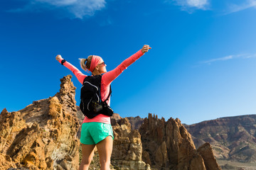 Woman hiker with arms outstretched enjoy mountains