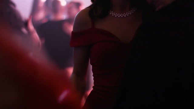  Beautiful heterosexual couple with no faces slow dancing at a club. Man keeps his female partner in a sensual dance. Medium shot. 