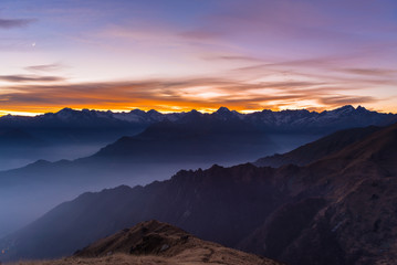 Mountain silhouette and stunning sky with moon at sunset
