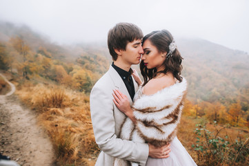 happy newly married couple posing in the mountains