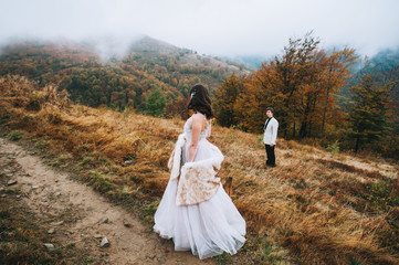 happy newly married couple posing in the mountains