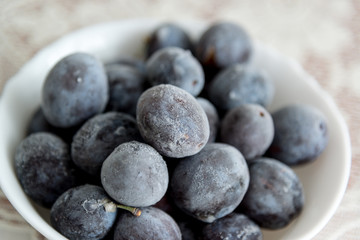 Frozen plums in  plate on the table