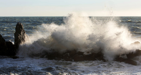 wave crashing over cliff