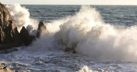 big wave crashing over rocks
