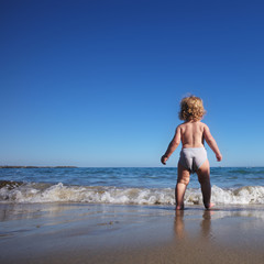 Baby boy walking on sea