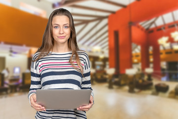 Woman holding a laptop and smiling
