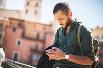 Young bearded traveller using his smartphone
