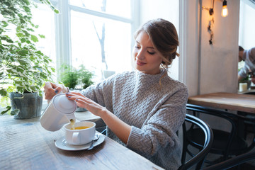 Fototapeta premium Woman drinking tea in cafe