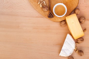Fototapeta na wymiar Cheese, walnuts, honey on a wooden table