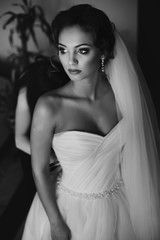 Bridesmaids helping gorgeous bride prepare for wedding closeup b
